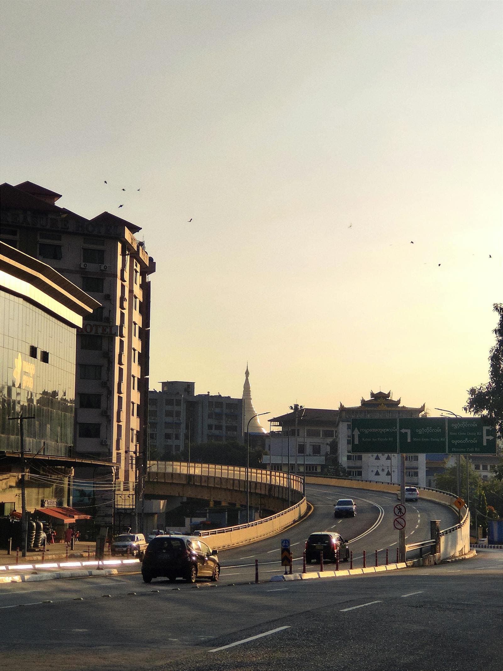 Yangon street scene with Buddhist pagoda at sunrise.