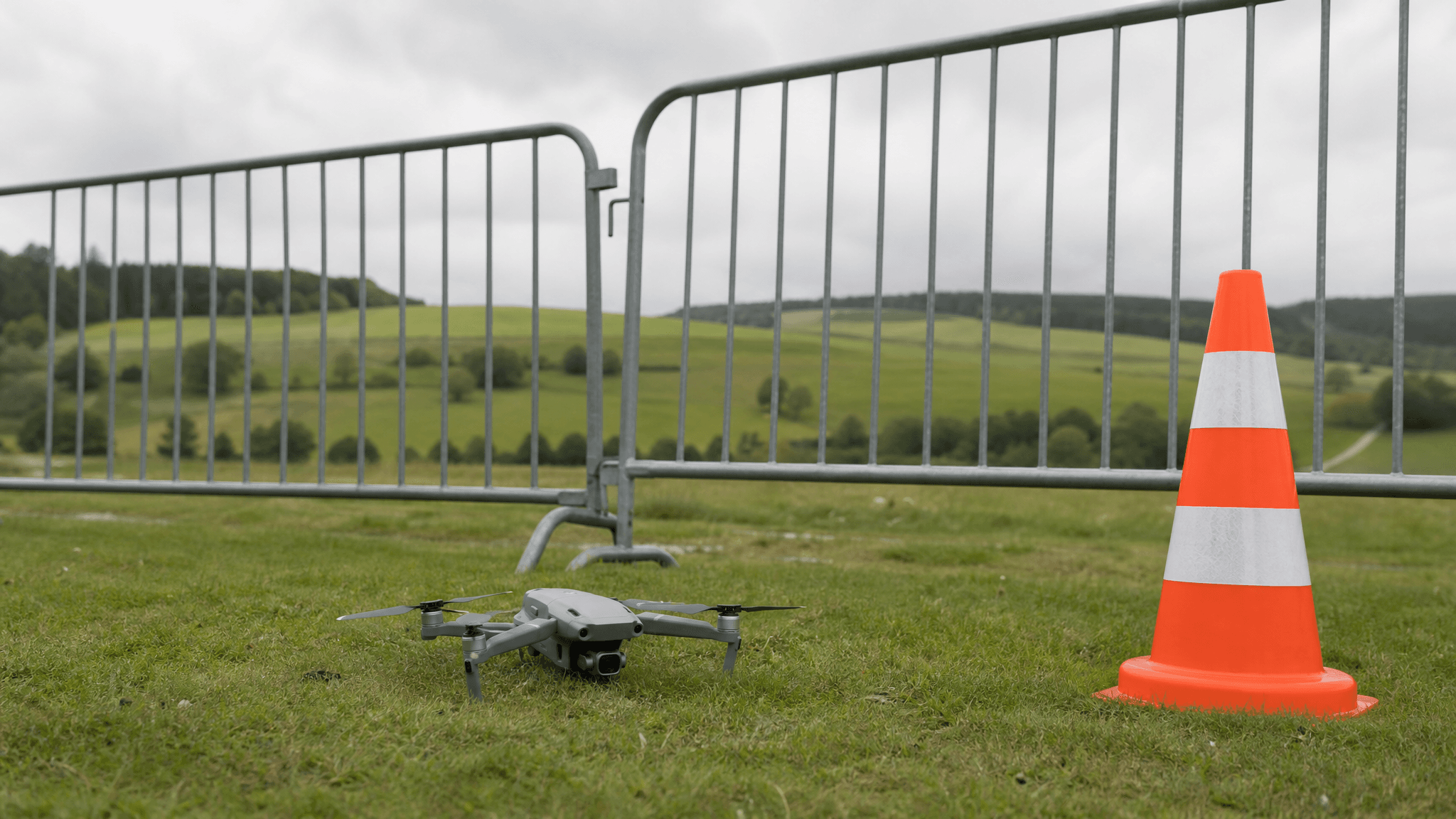 A small consumer drone grounded near an event safety perimeter.