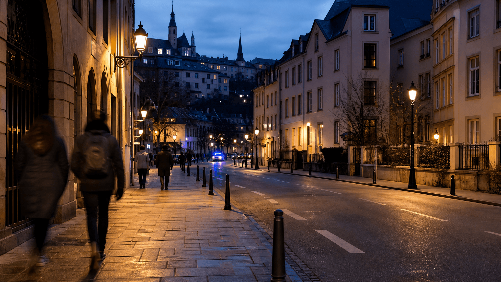 Quiet Luxembourg street at dusk with distant police presence.