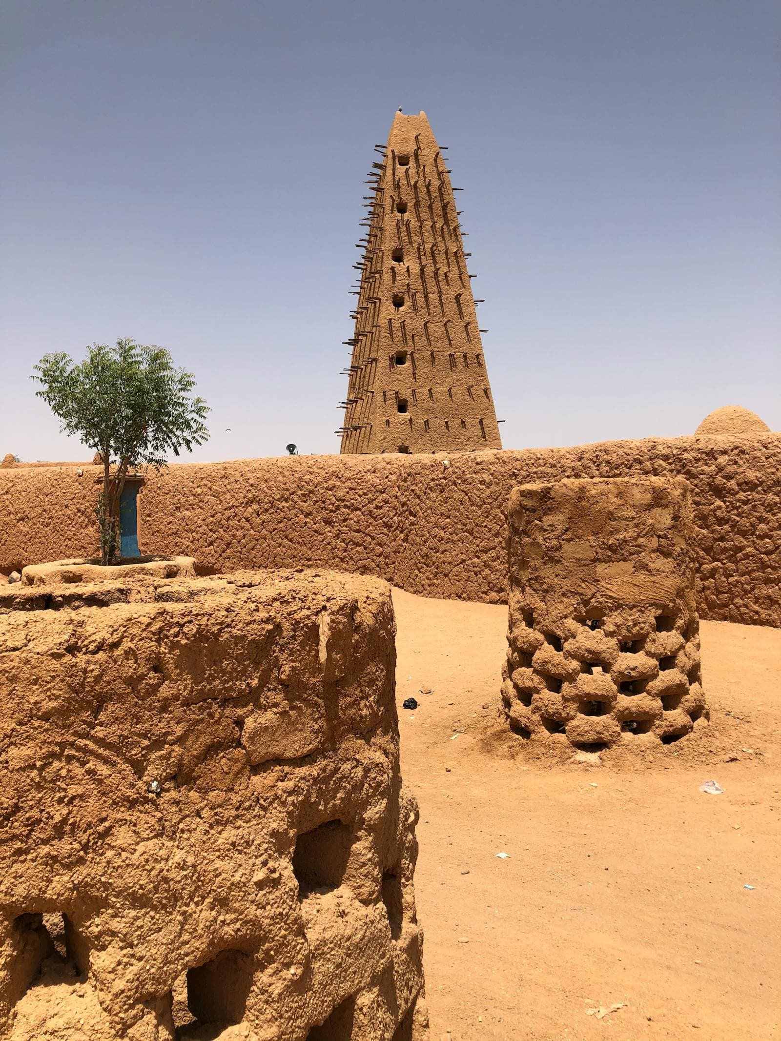 Historic mud-brick Grande Mosquée d'Agadez amid Sahel desert sand.