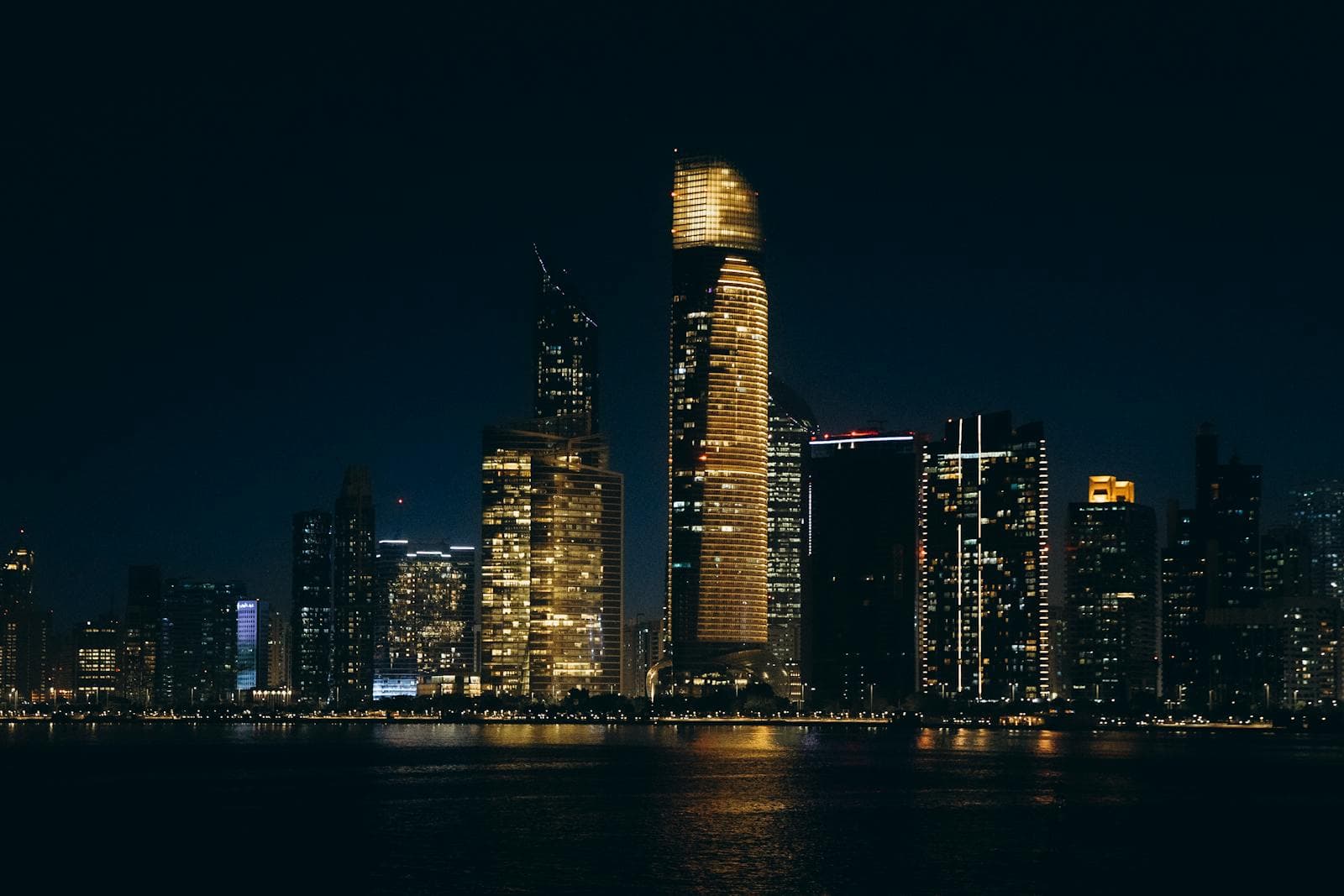 Illuminated Abu Dhabi skyline at night.